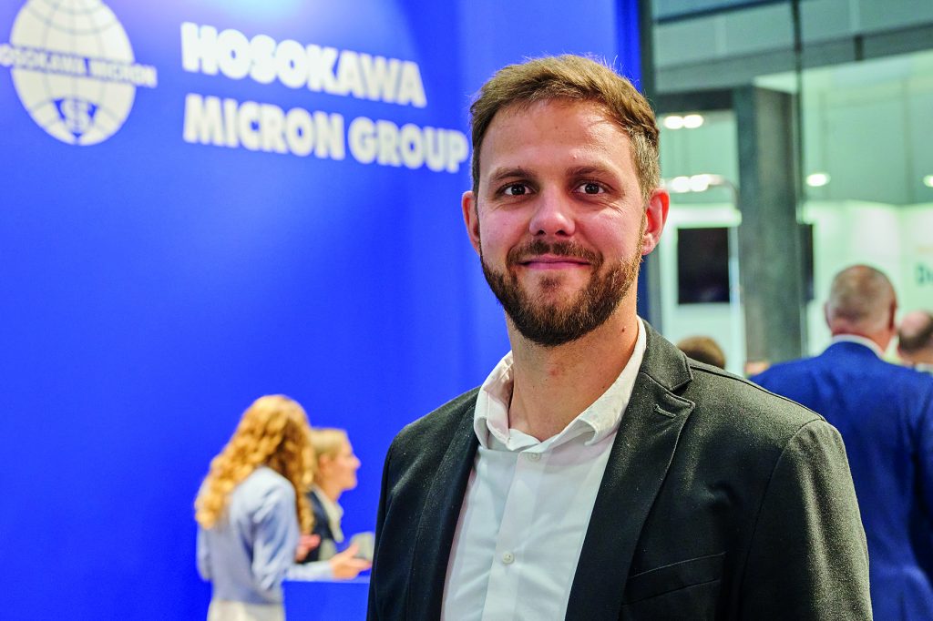 Thomas Kubina, Mitarbeiter der Hosokawa Micron Group steht am Messestand der Powtech Technopharm 2025