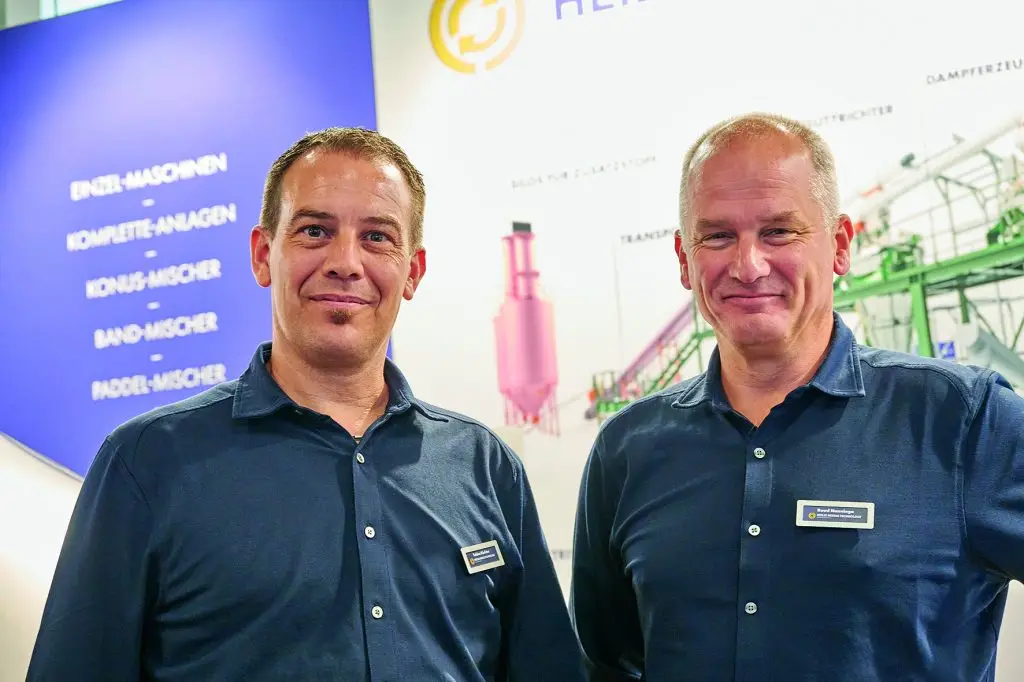 Tobis Röchter und Ruud Nanninga Mitarbeiter der Heilig Mixers stehen am Messestand der Powtech Technopharm 2025