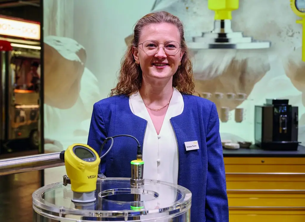 Mitarbeiterin der Vega steht am Messestand