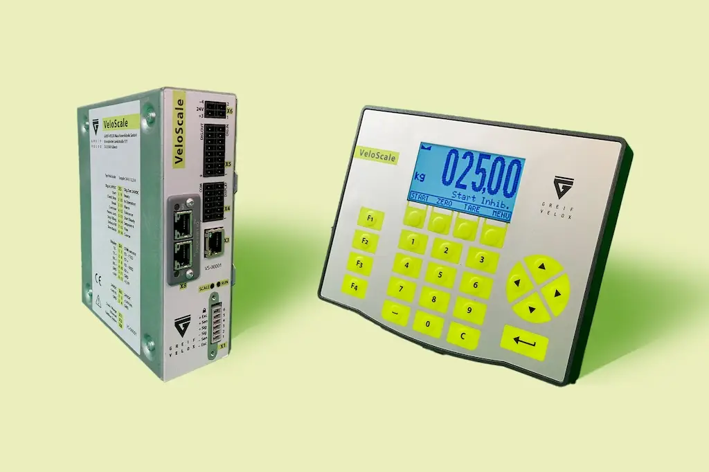 Zwei Komponenten des Velo Scale. Links eine Box mit verschiedenen Steckanschlüssen. Rechts ein Kasten mit Zahlen und Tasten und einem Display mit Zahlen