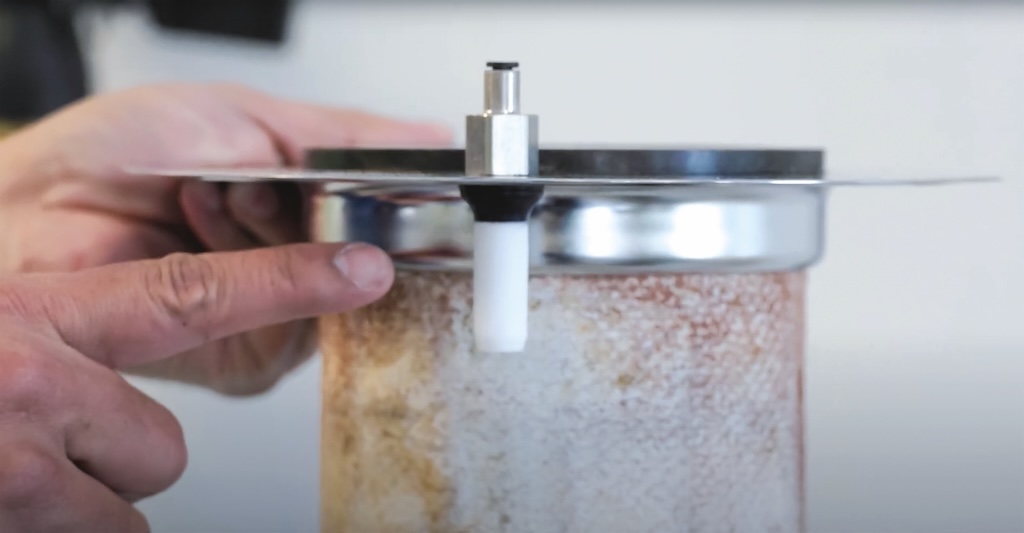 Wir sehen eine metallplatte mit einem Sensor. Ein Finger zeigt auf den sensor