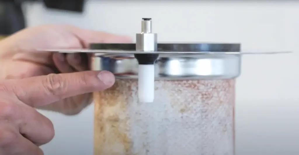 Wir sehen eine metallplatte mit einem Sensor. Ein Finger zeigt auf den sensor