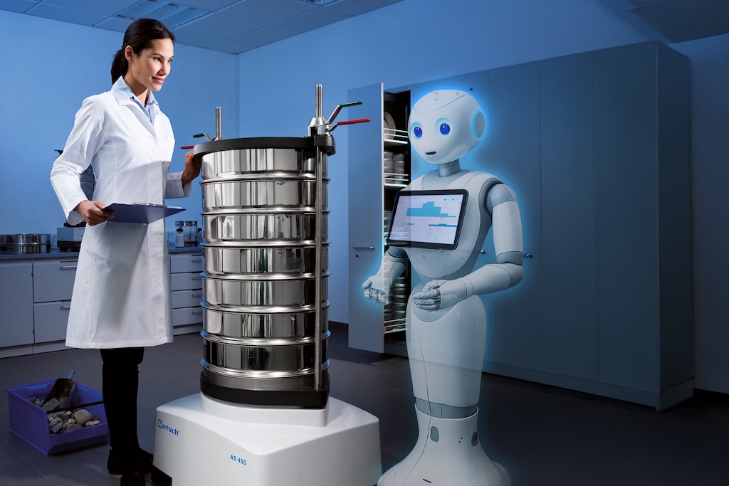 Ein Labor in dem Hologrphisch Ein Roboter neben einer Mascheine und einer Frau abgebildet ist