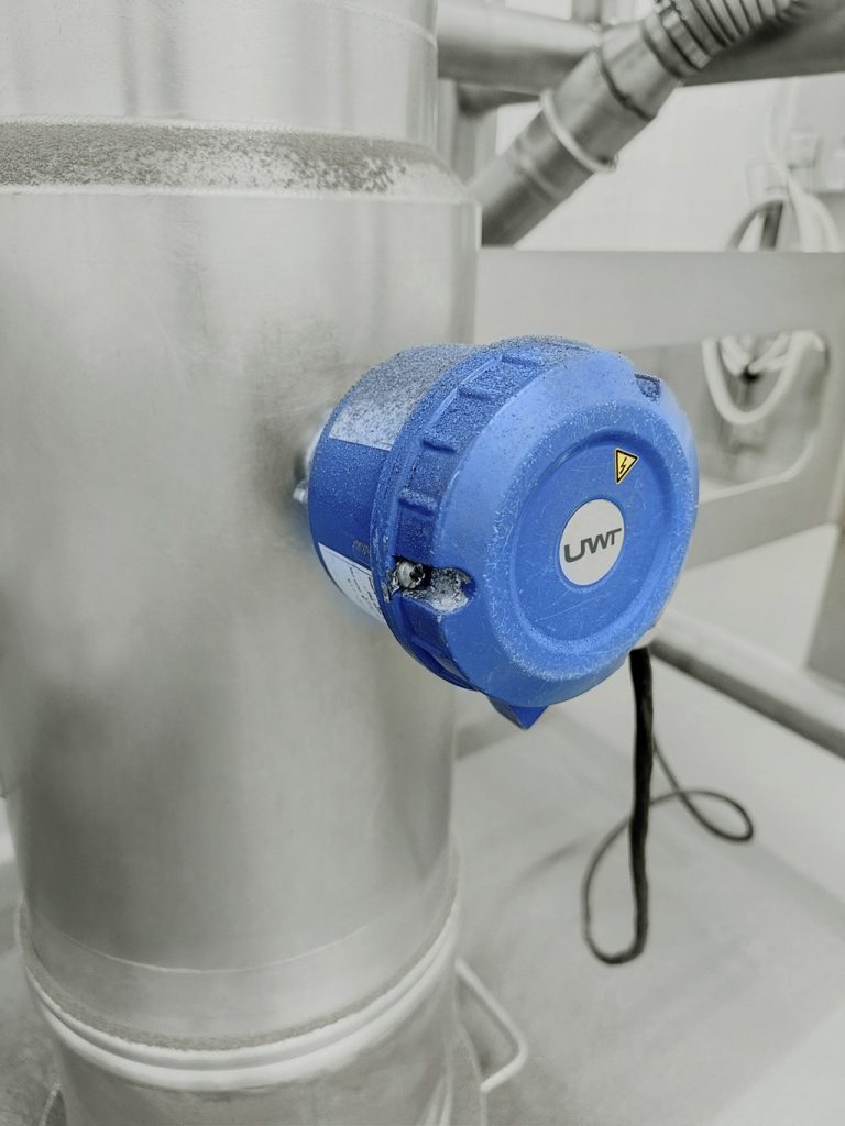 Sensor der UWT in einer Industriehalle an einem Rohr angebracht.