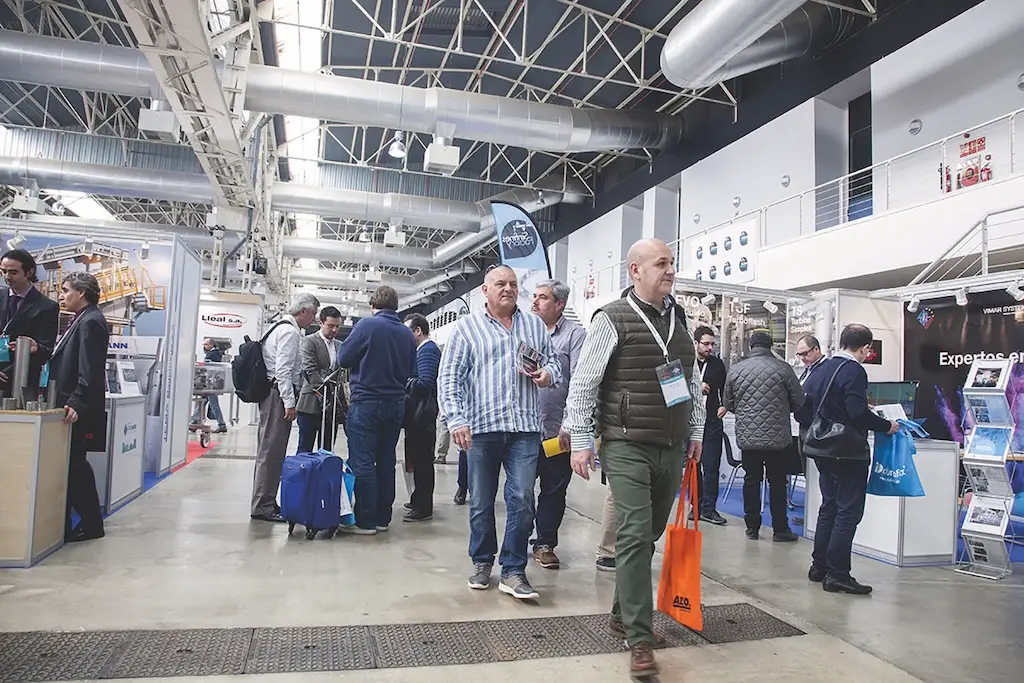 Besucher einer Messe gehen durch die Messehalle