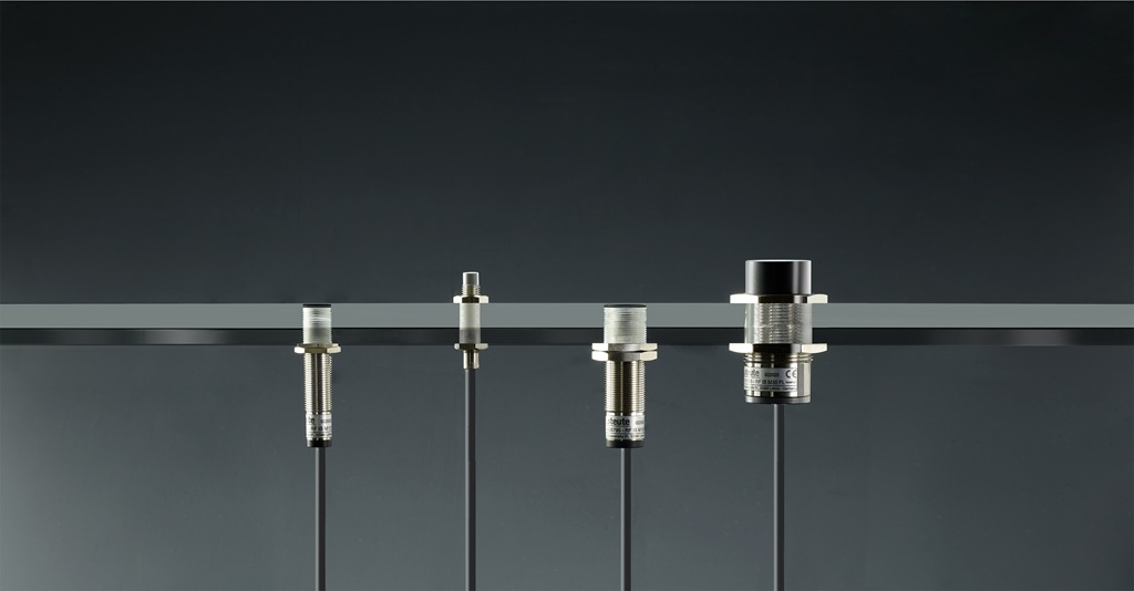 Produktbild mit vier unterschiedlichen Funk-Induktivsensoren vor schwarzem Hintergrund