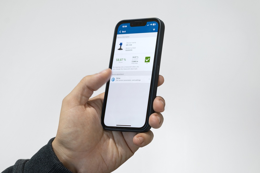 Applikation auf einem Mobiltelefon das von einer Linken Hand gehalten wird.