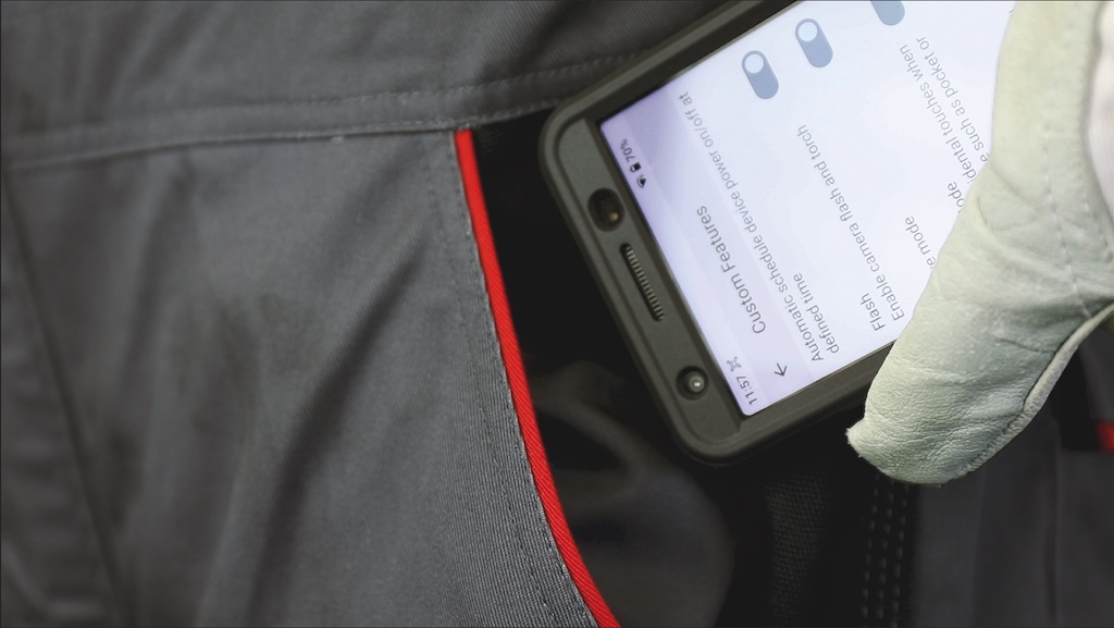 Smartphone welches gerade in die Hosentasche gesteckt wird