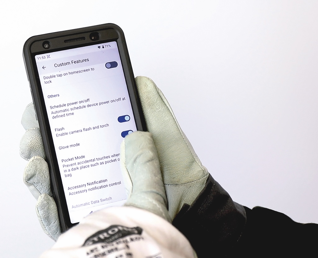 Smartphone welches von einem Weißen Handschuh bedient wird.