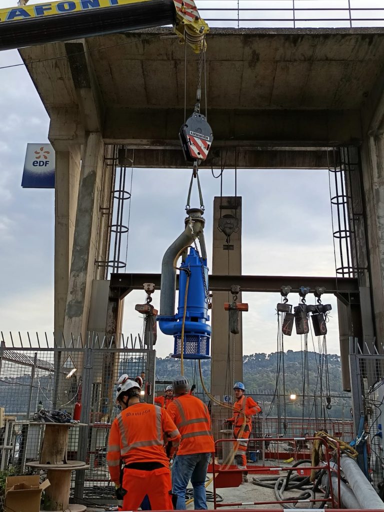 Pumpe wird in eine Bautelle gehoben