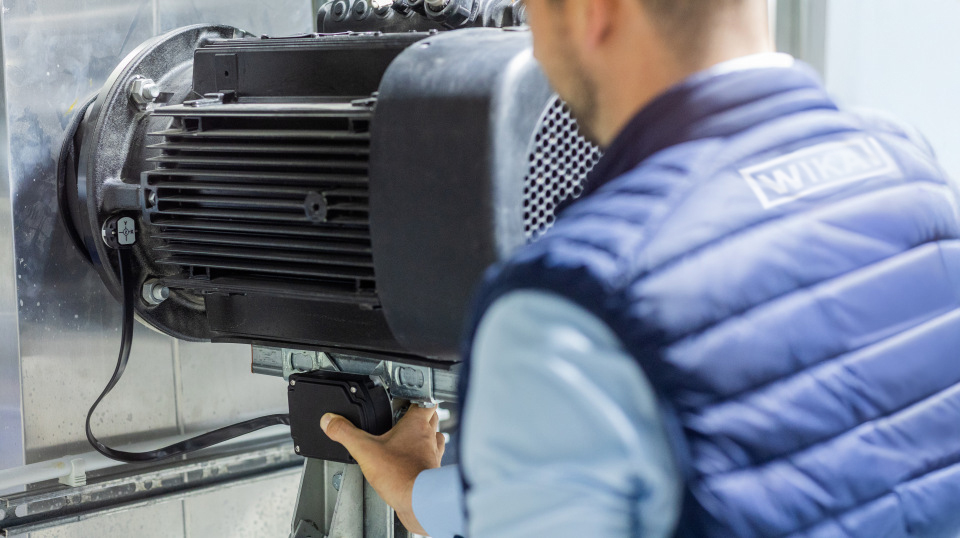 Rücken eines Mitarbeiters vor einem Industrieantrieb