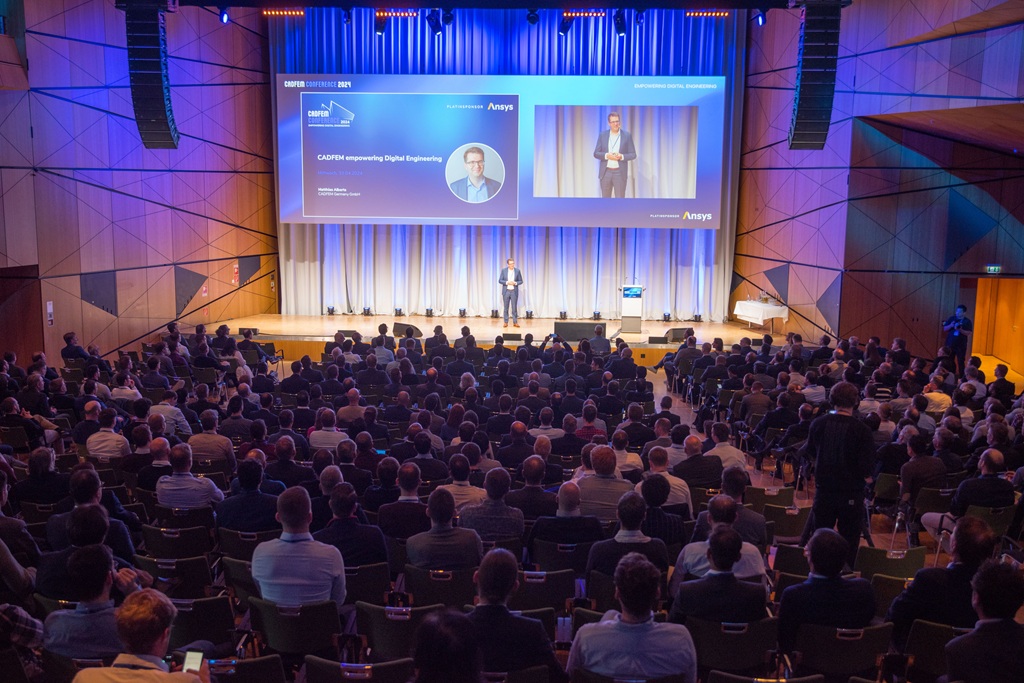 Volles Plenum des "damstadtium" bei einer Konferenz. Publikum wendet uns den Rücken zu, Redner steht alleine auf der Bühne.