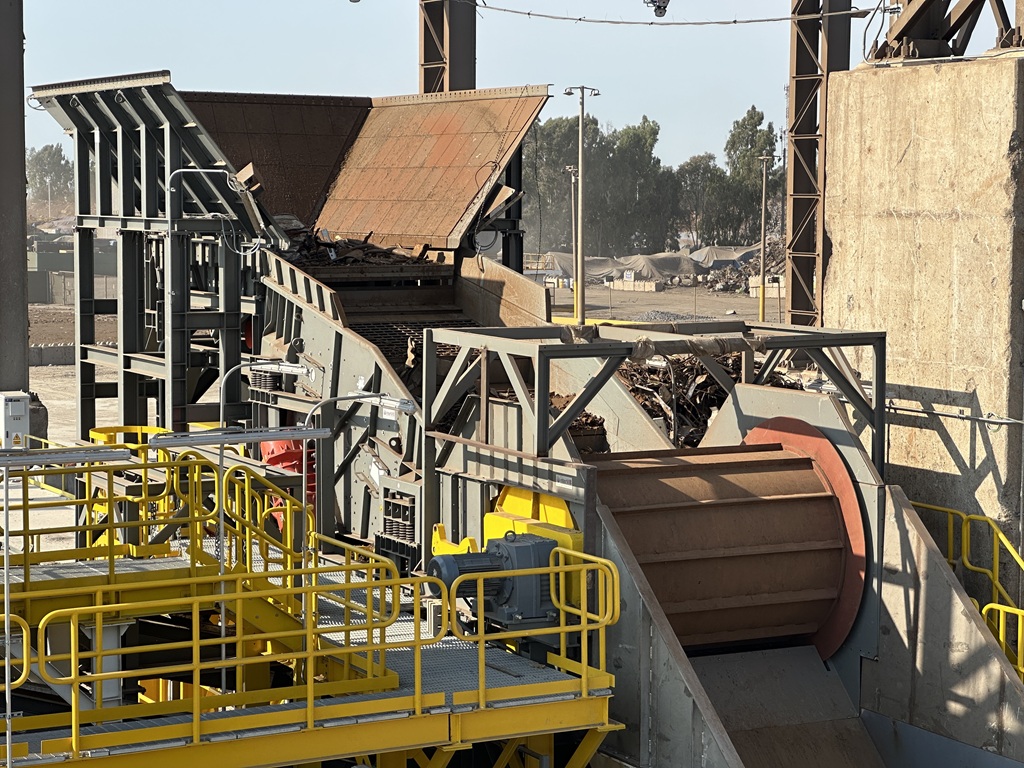 Schrottreinigungsanlage – im Hintergrund ein Sammelbehälter. Im Vordergrund eine Schütte mit einer großen Tragerolle