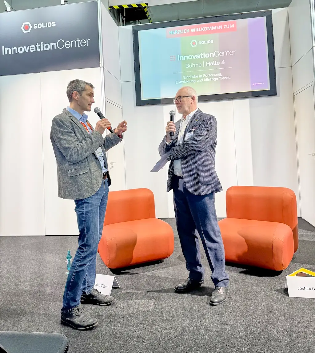Moderation auf der Bühne im SOLIDS InnovationCenter Halle 4 zu Trends in Forschung und Entwicklung der Schüttgutindustrie.