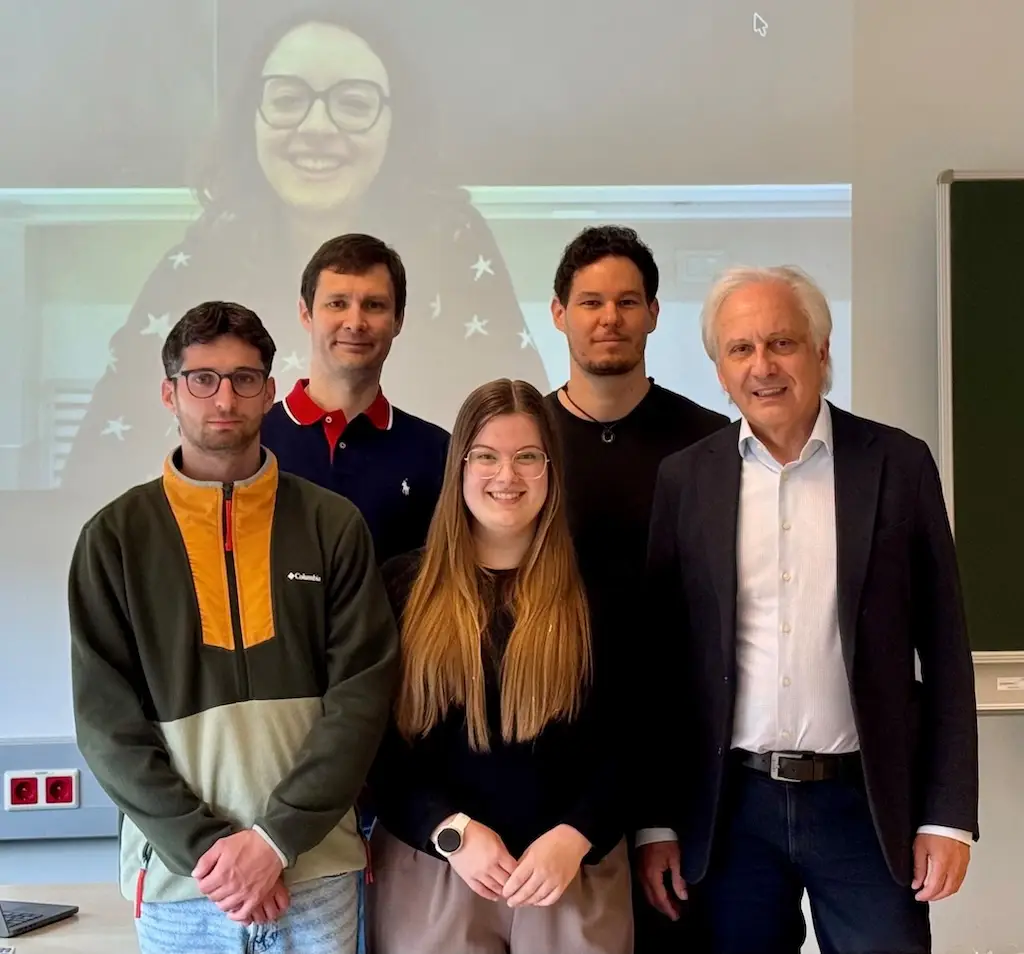 Francesco Zuccato, Benedetta Strizzolo (zugeschaltet auf der Leinwand), Konstantin Schekotihin, Veronika Semmelrock, Patrick Rodler und Gerhard Friedrich bei einer Fachveranstaltung oder Präsentation. Die Teilnehmenden diskutieren aktuelle Entwicklungen und Innovationen in ihrem Fachgebiet.