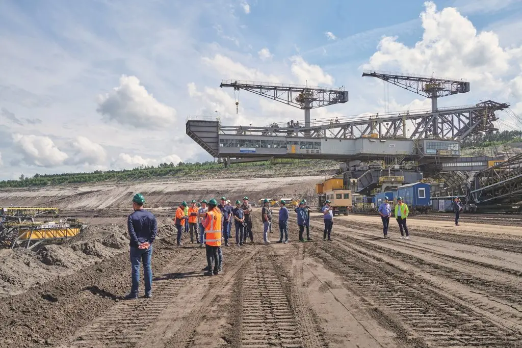 Schaufelradbagger im Braunkohletagebau mit Besuchergruppe auf der Abbaufläche
