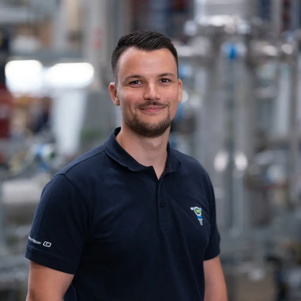 Fachperson der Prozessindustrie vor industrieller Anlagentechnik in Produktionsumgebung