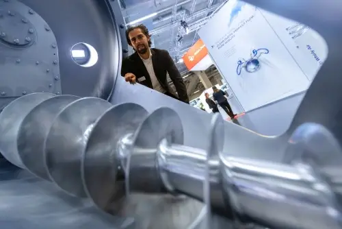 Förderschnecke als Komponente der Schüttgutfördertechnik auf einem Messestand der POWTECH 2025 mit Exponaten der Verfahrenstechnik.