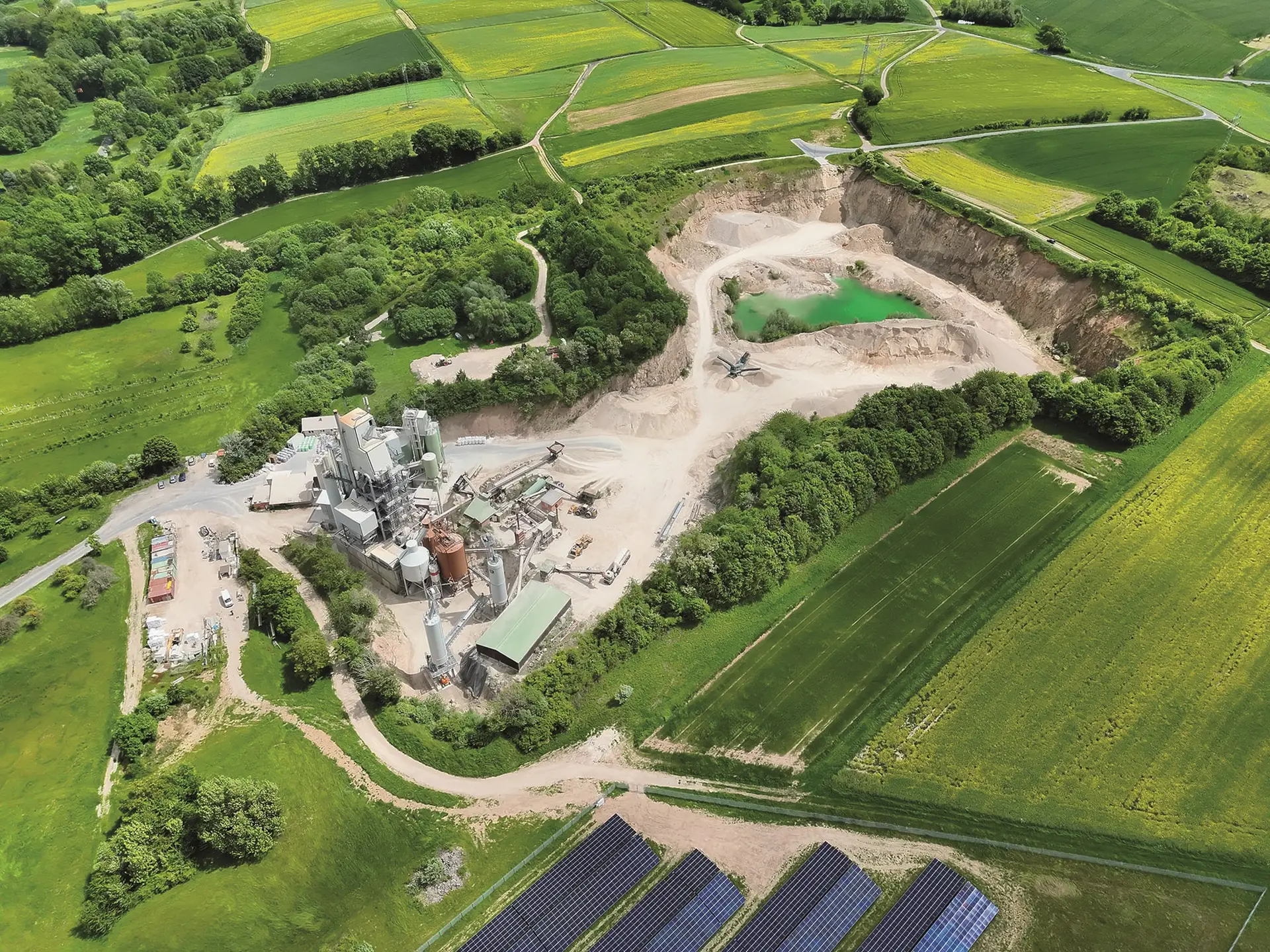 Luftaufnahme des Dolomitsteinbruchs und Produktionsstandorts von Köhler Kalk mit Aufbereitungsanlagen, Abbauflächen und Infrastruktur zur Gewinnung und Verarbeitung von Dolomitkalk.