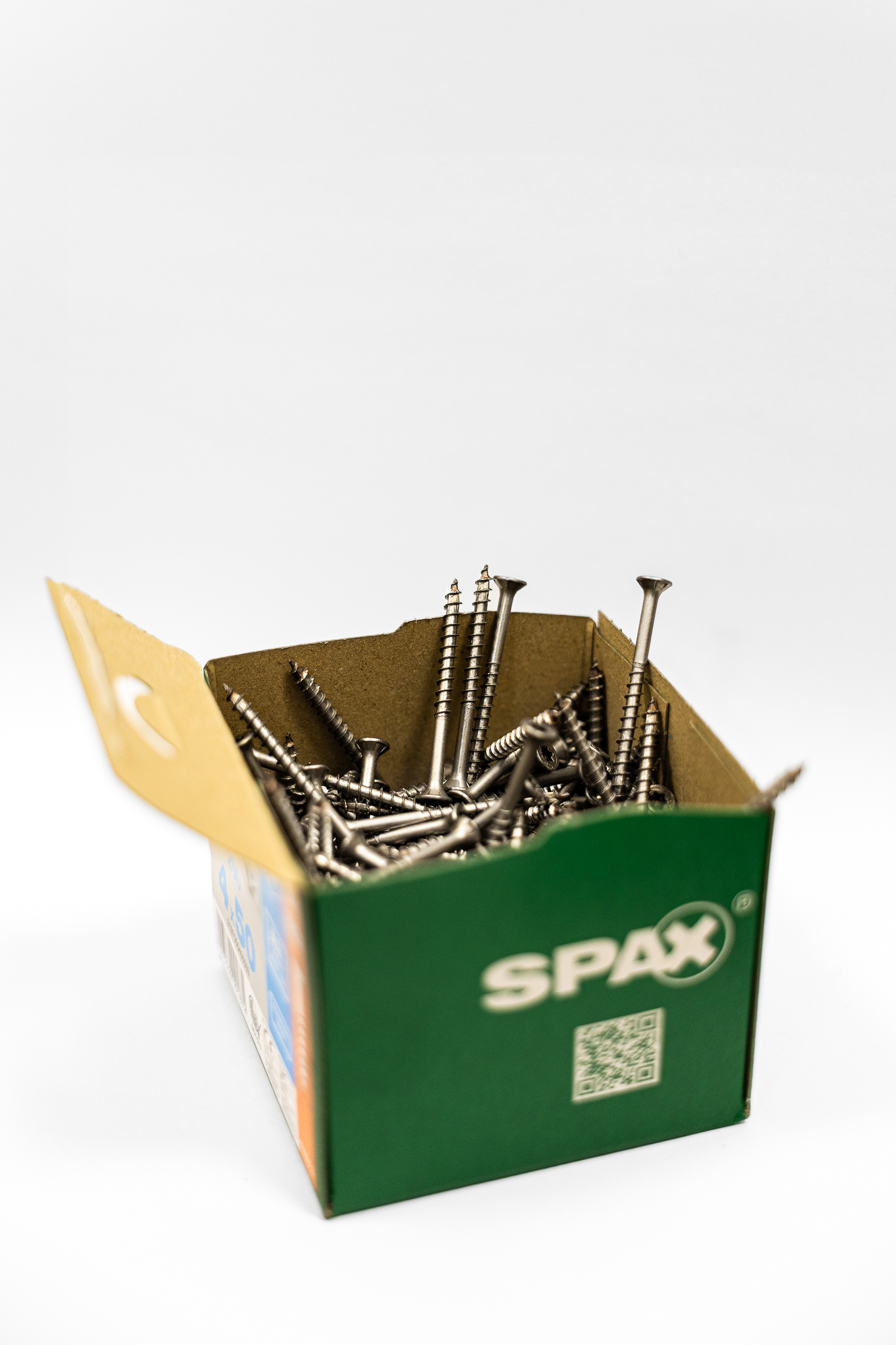 SPAX-Schrauben im Karton mit aufgerichteten und verhakten Schrauben (Igelbildung) nach der automatisierten Befüllung.