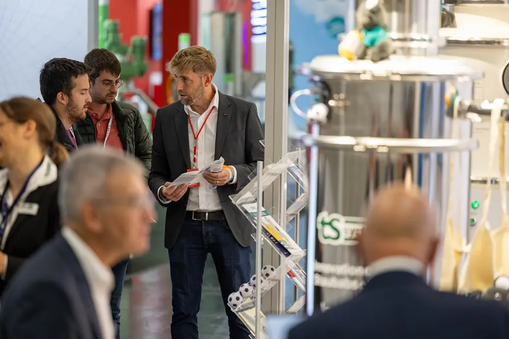 Fachbesucher im Gespräch an einem Messestand der POWTECH TECHNOPHARM in Nürnberg.