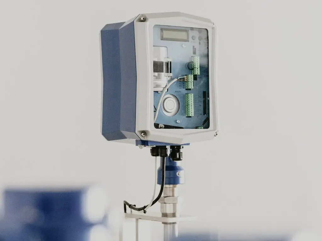 Messgerät mit blau-grauem Gehäuse und geöffneter Front, Blick auf Display, Klemmleisten und Elektronikplatine